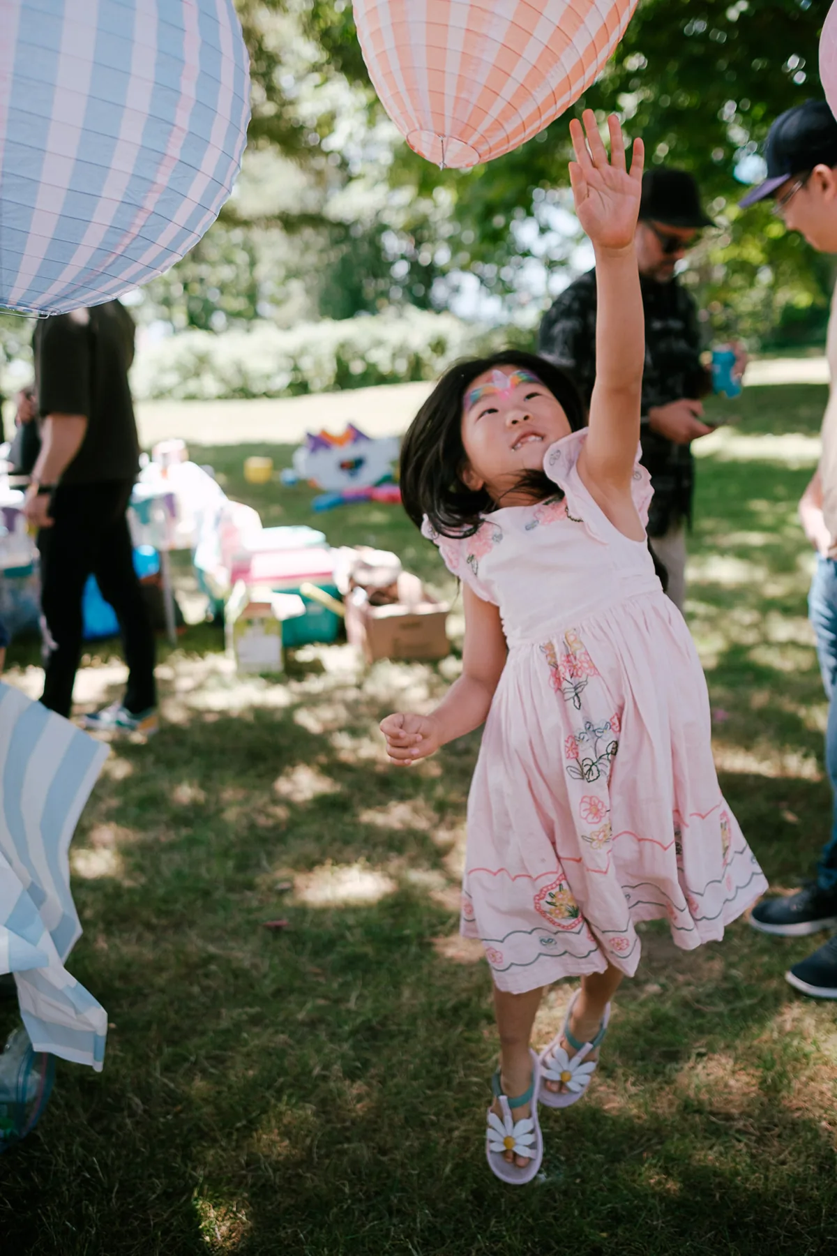Child reaching for a lantern at a birthday party