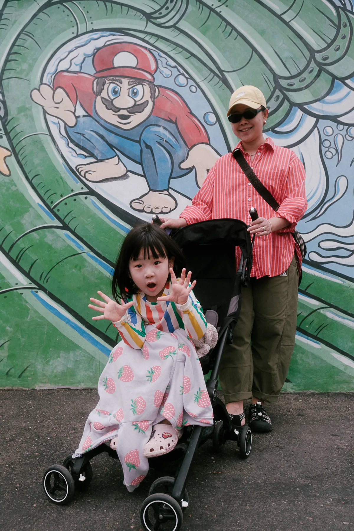 Parent and child beside a colorful mural