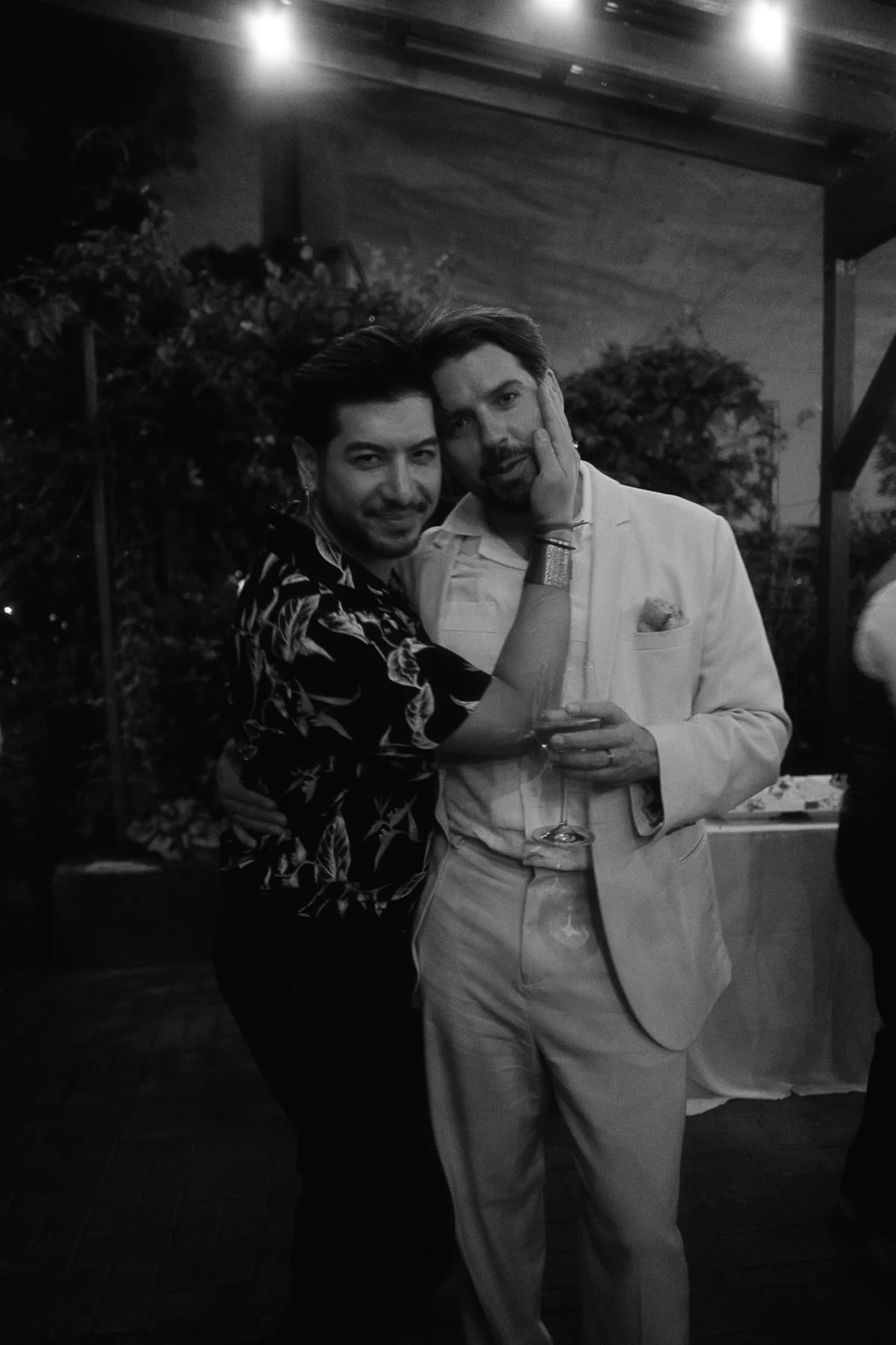 Two guests embracing at a wedding reception
